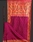 Saree with pink and orange patterned fabric draped over a rod