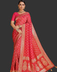 Woman wearing a red saree with gold patterns on an orange background