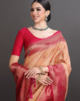 Woman wearing a red blouse and beige saree with jewelry against a gray background