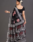 Woman wearing a black saree with red and white patterns on a gray background