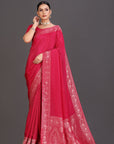 Woman wearing a red saree with white patterns on a gray background