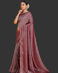 Woman wearing a maroon saree with a subtle pattern on an orange background
