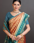 Woman wearing a traditional saree with a blue and orange pattern on a dark background