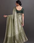 Woman wearing a green saree with a dark background
