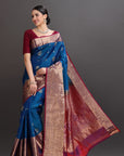 Woman wearing a blue and red saree with a dark background