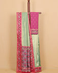 A mint green and magenta pink traditional Indian saree displayed on a wooden hanger against a solid beige background. The saree features a wide magenta border with intricate gold and white patterns, a solid mint green body, and a matching pink blouse piece with small gold dots.