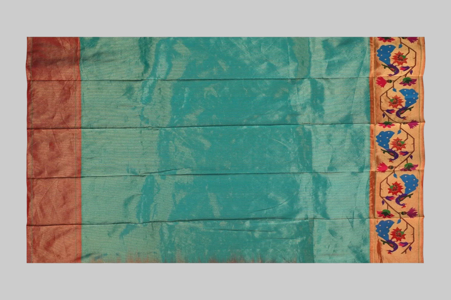 Teal saree with a colorful border on a white background