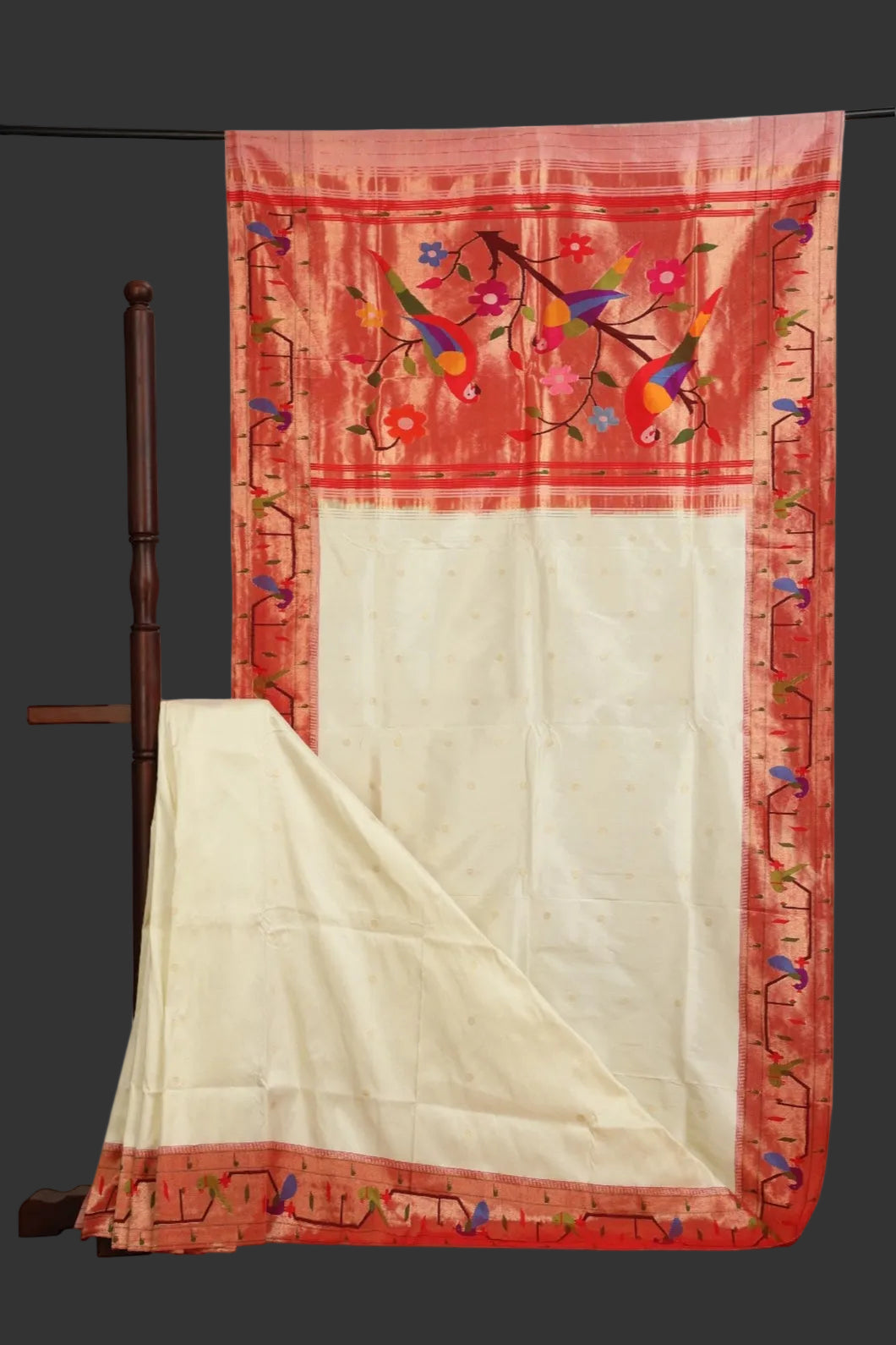Red and white saree with floral embroidery on a stand