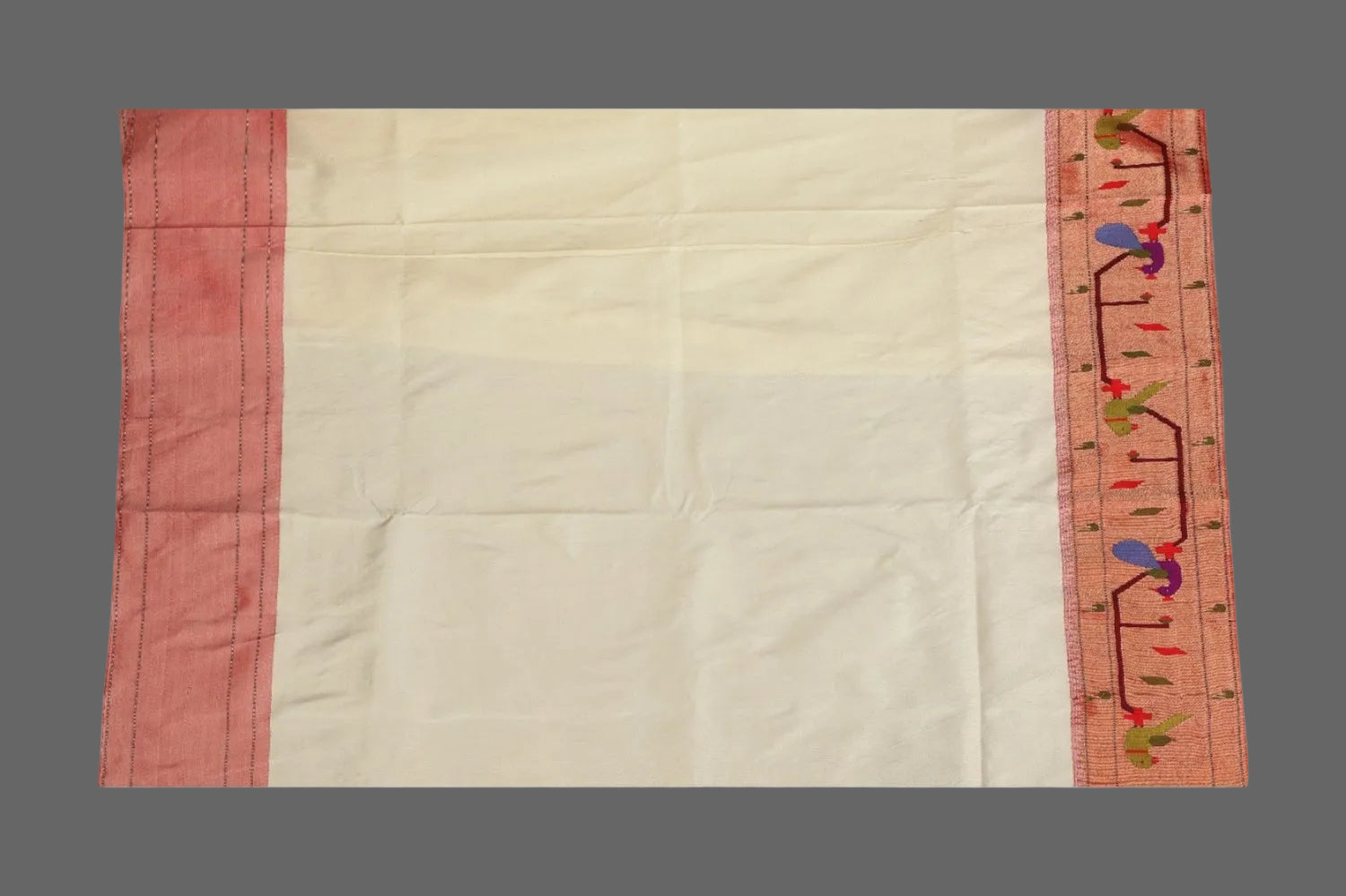 Saree with pink border and floral embroidery on a white background