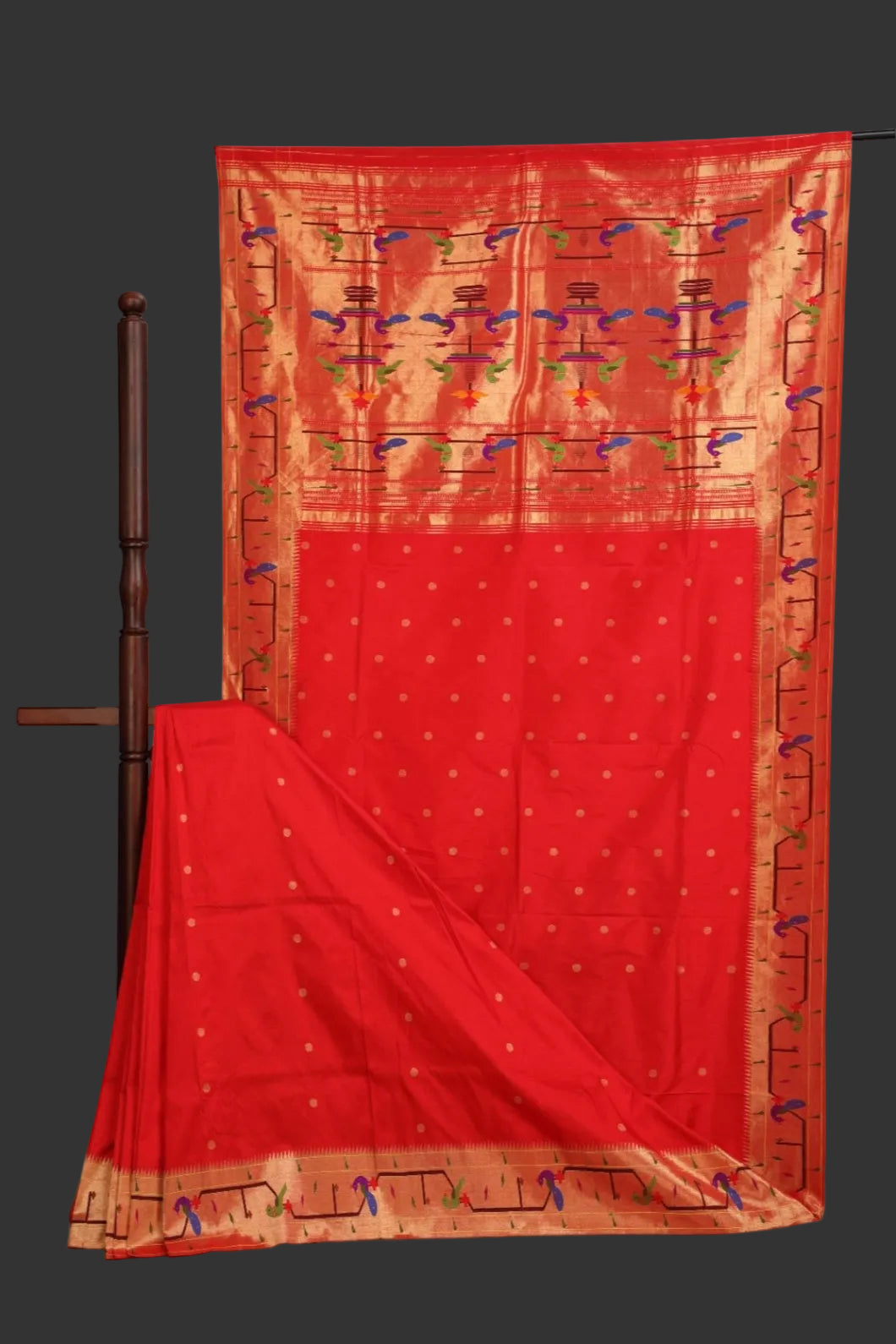 Red saree with gold border and patterns on a white background