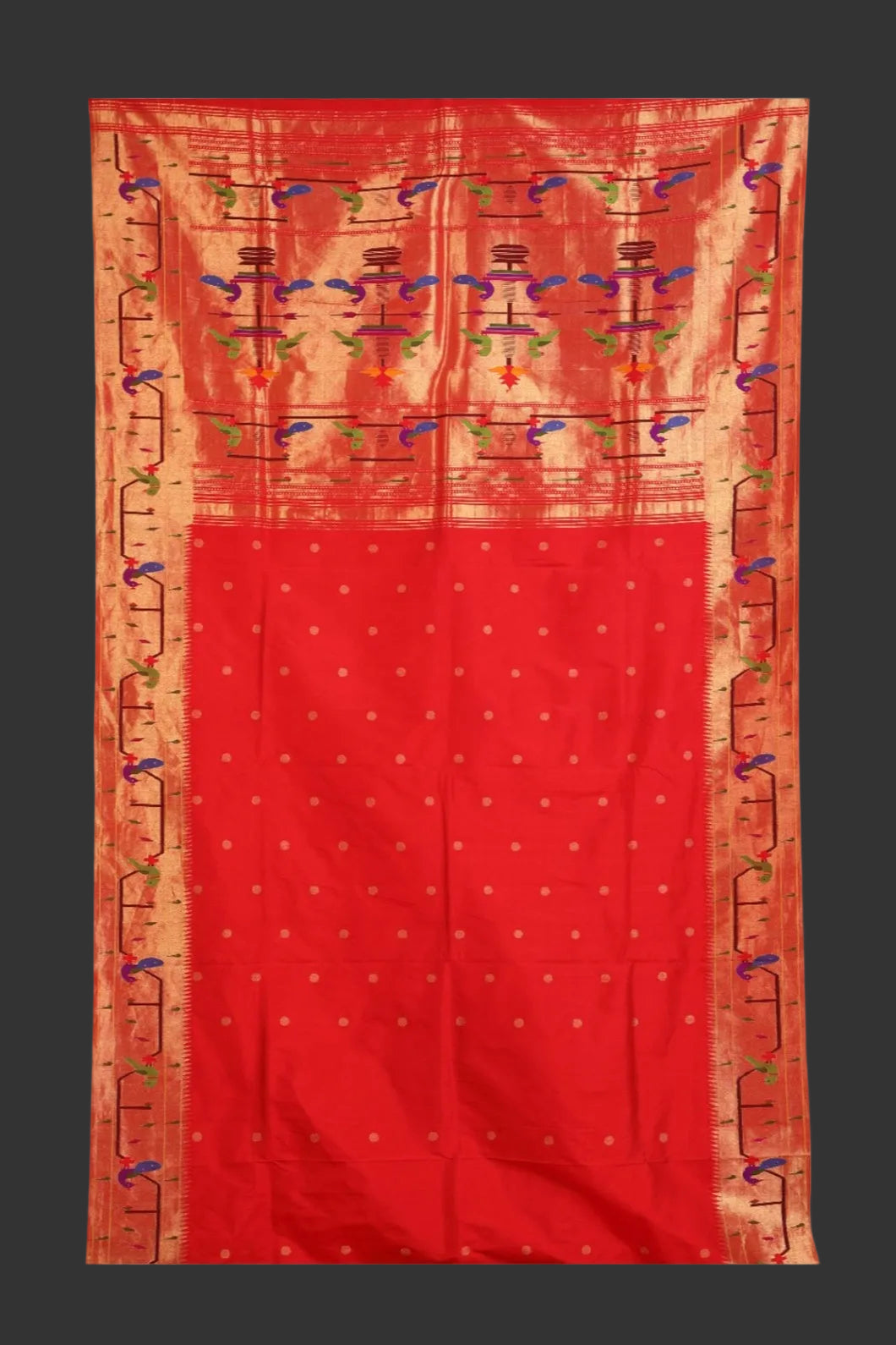 Red fabric with intricate gold and multicolor patterns on a white background
