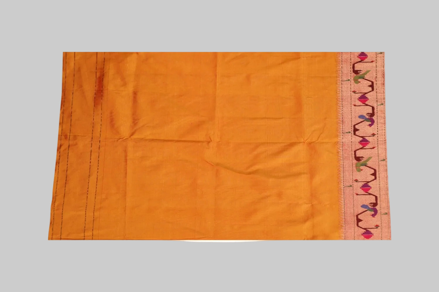 Orange fabric with a decorative border on a white background
