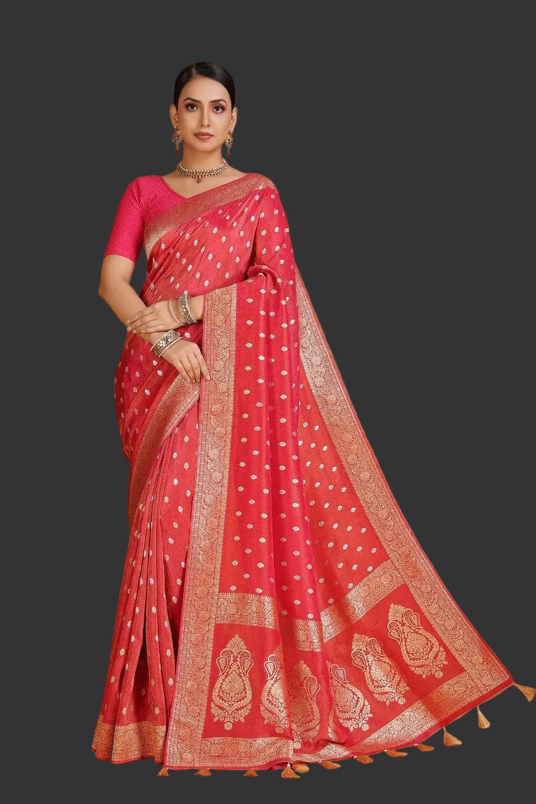 Woman wearing a red saree with gold patterns on an orange background