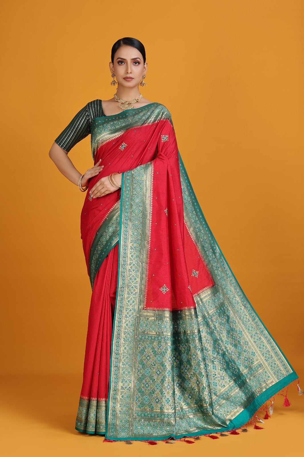 Woman wearing a red and green saree on an orange background