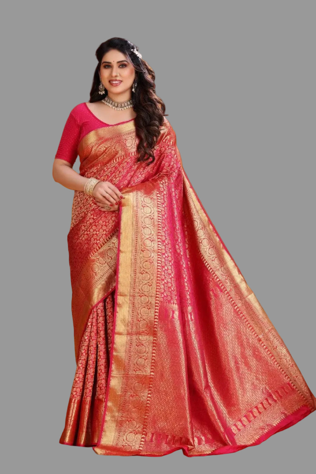 Woman wearing a red saree with gold patterns on an orange background