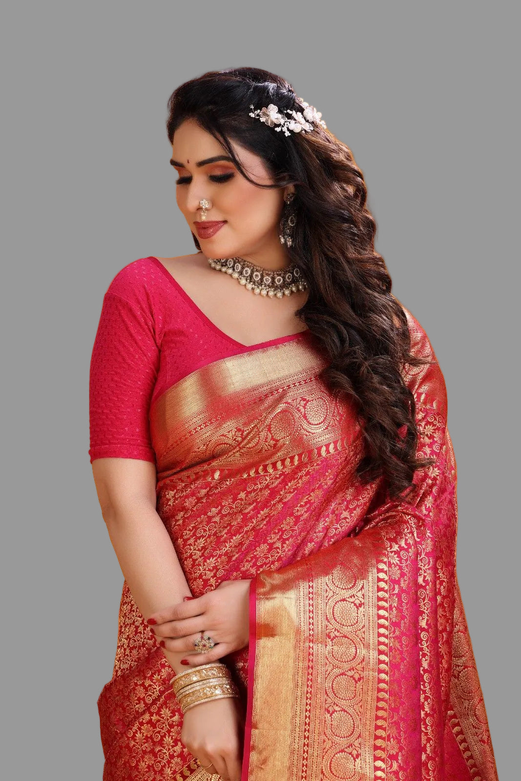 Woman in a red saree with gold patterns on an orange background