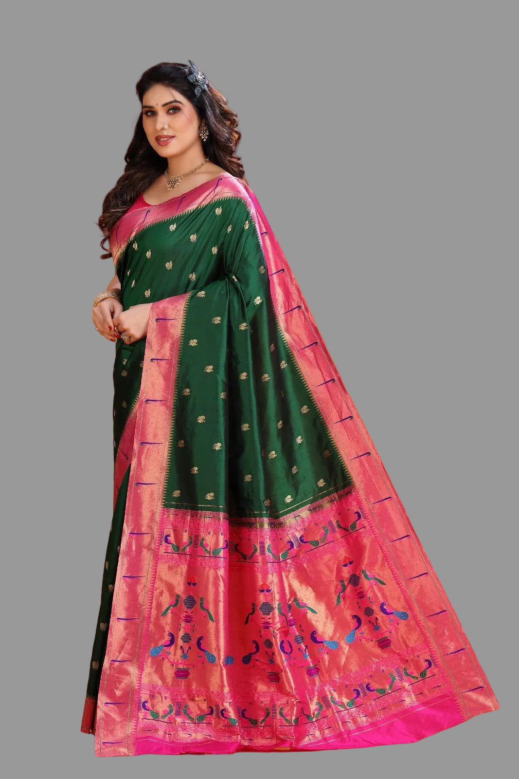 Woman wearing a green and pink paithani saree with a floral blouse against an orange background