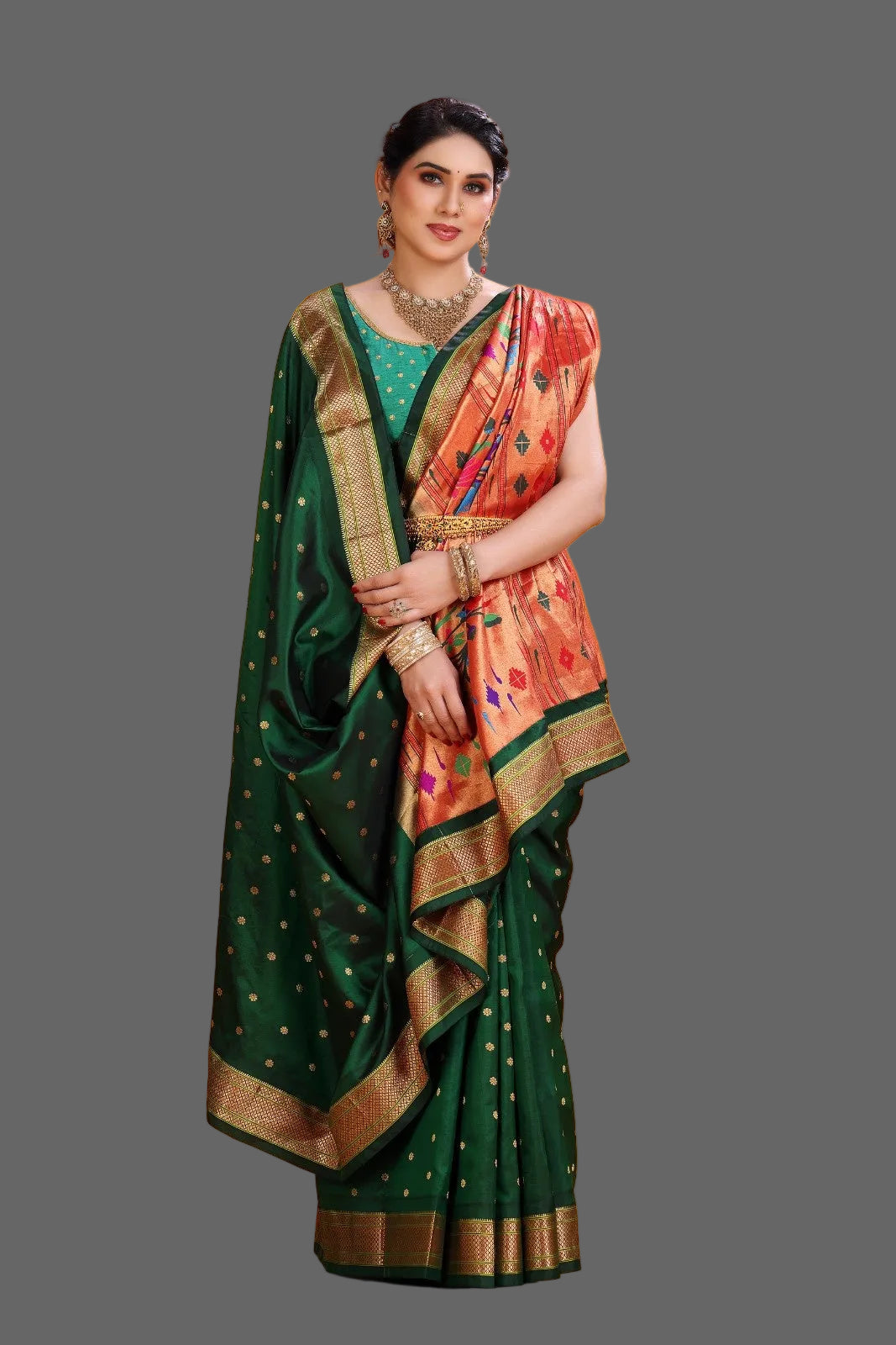 Woman wearing a green and orange paithani saree with a gold border on an orange background