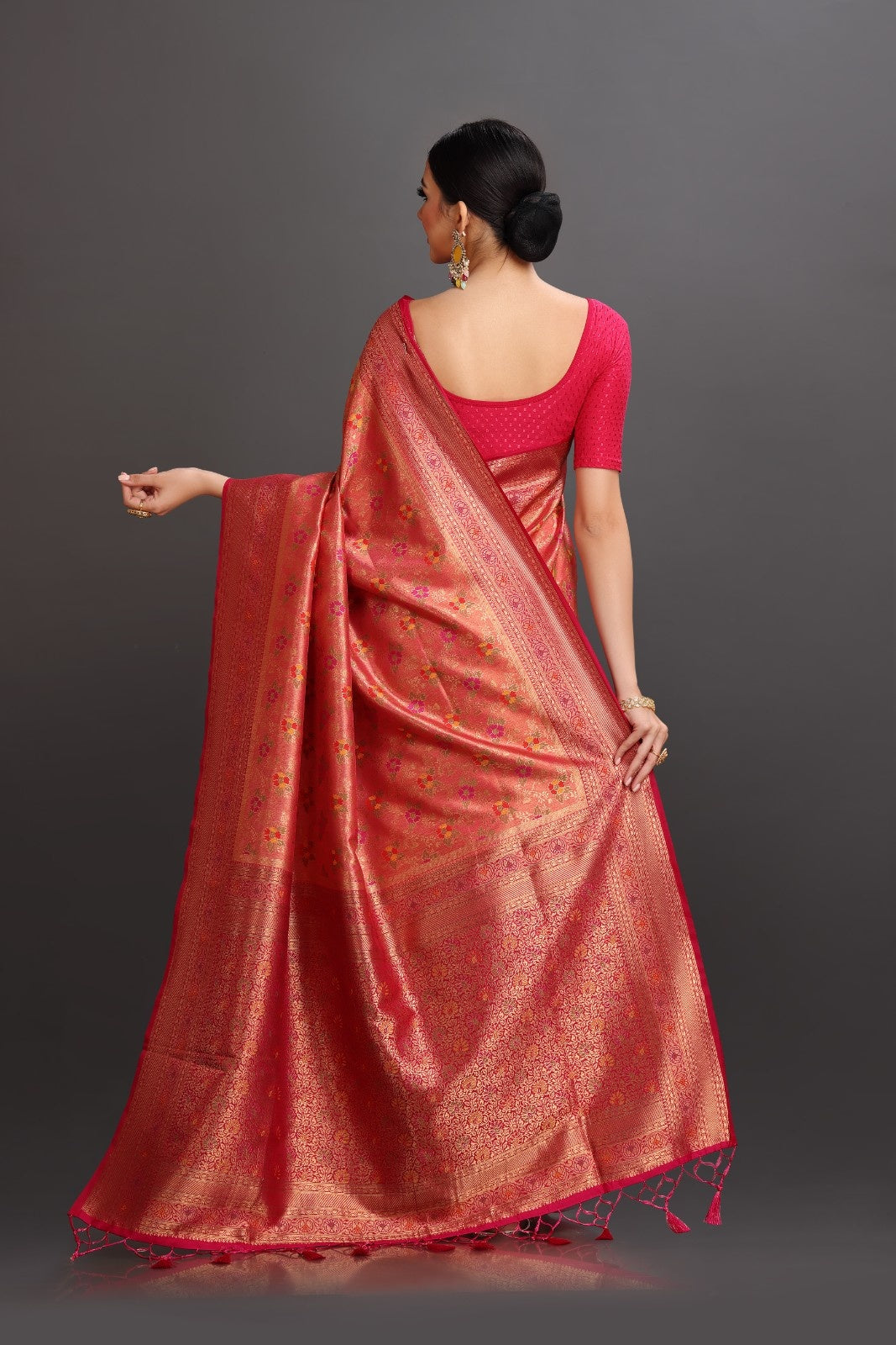 Woman wearing a red saree with a dark background