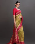 Woman wearing a green and red saree on a gray background