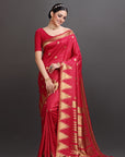 Woman wearing a red saree with gold patterns on a gray background