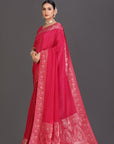 Woman wearing a red saree with intricate patterns on a gray background