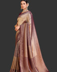 Woman wearing a traditional saree with a gold and brown pattern on an orange background