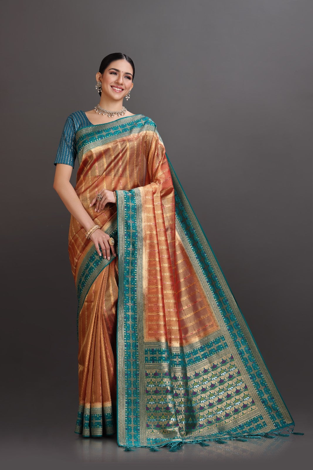 Woman wearing a traditional saree with a gradient design on a gray background