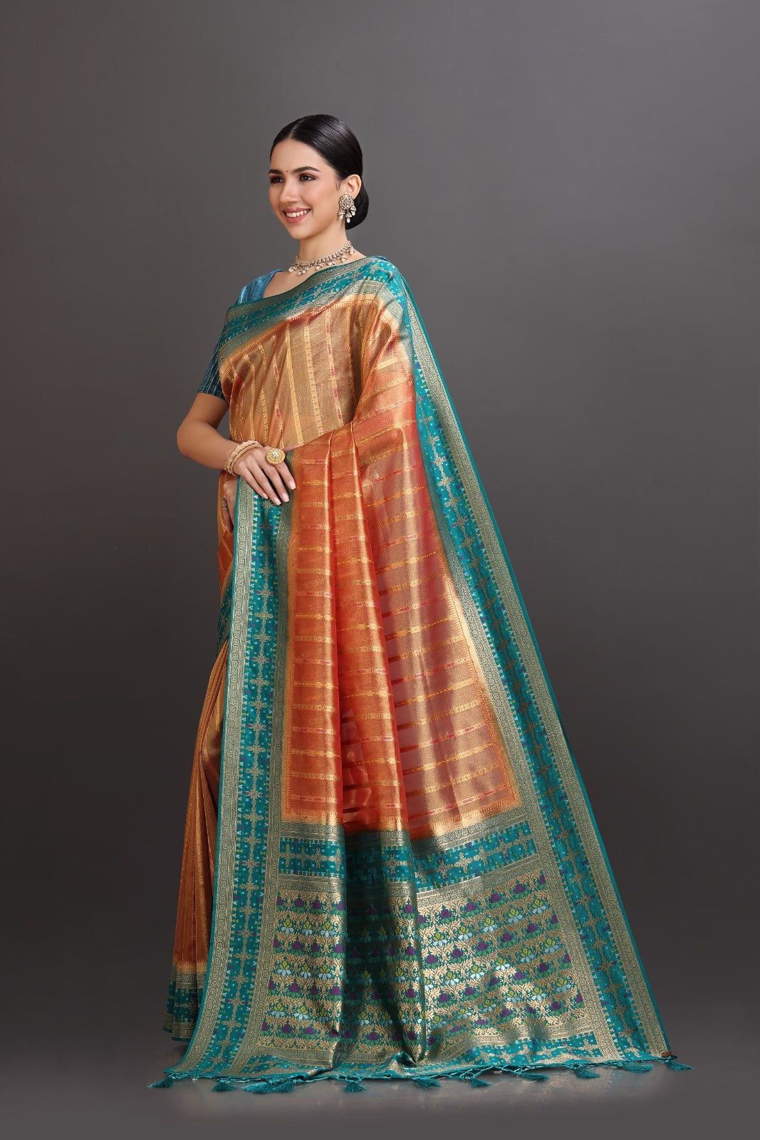 Woman wearing a traditional saree with a gradient of colors on a gray background