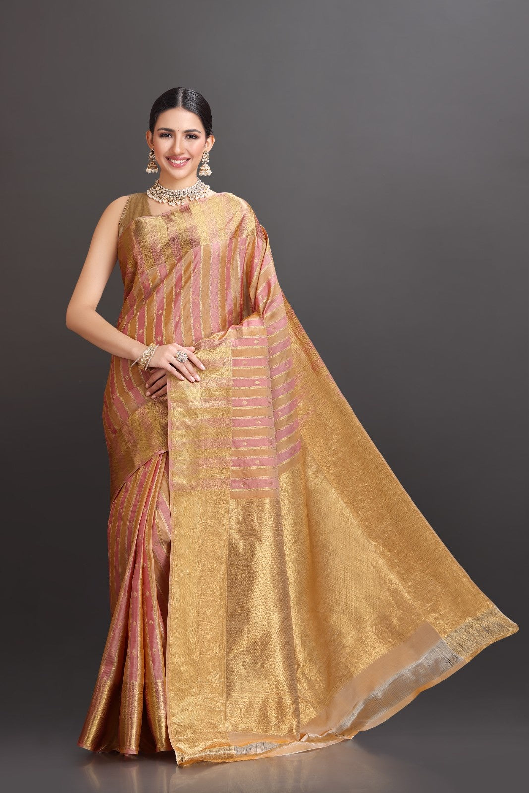 Woman wearing a gold saree with a dark background