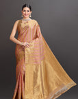 Woman wearing a gold saree with a dark background