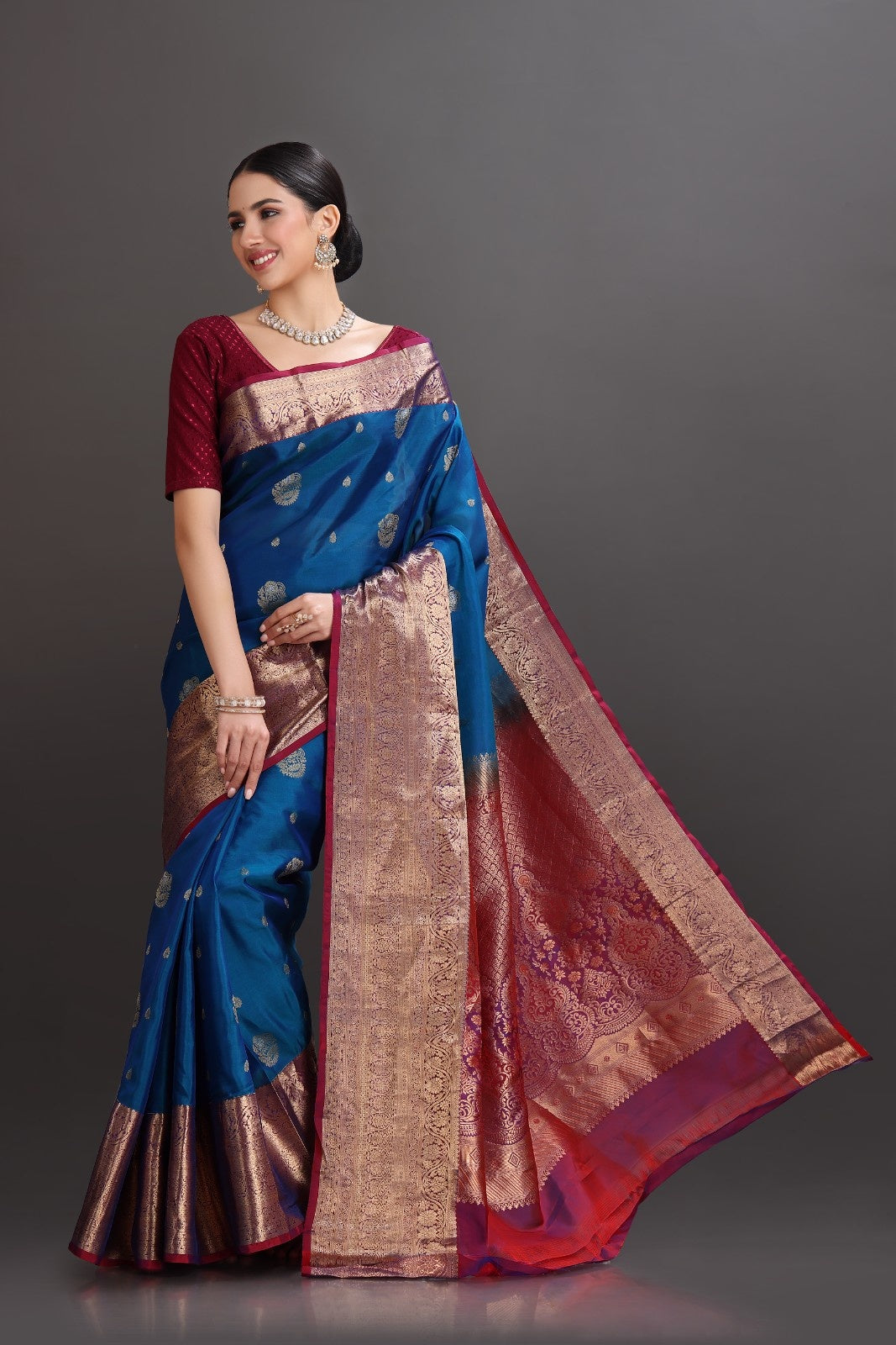 Woman wearing a blue and red saree with a dark background