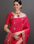 Woman wearing a traditional red saree with gold patterns on a gray background
