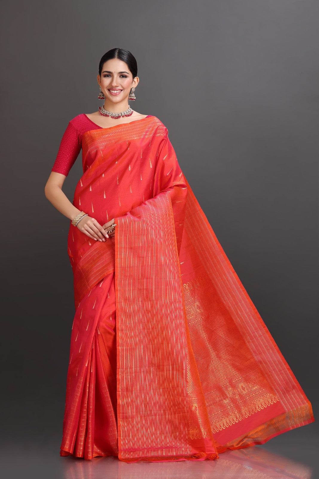 Woman wearing a red saree with a plain background